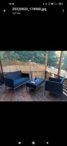 twee blauwe banken en een tafel op een patio bij U San Francescu Maisonette Modulaire Type studio in Volpajola