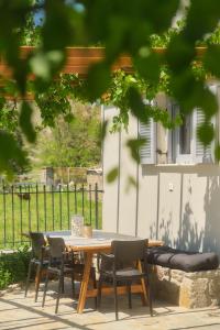 une table et des chaises en bois devant une clôture dans l'établissement Heliotopos, à Skala Eresou