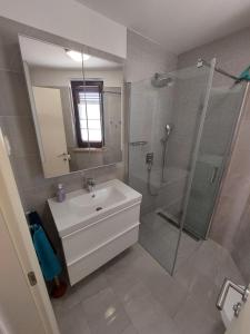 a bathroom with a white sink and a shower at Apartment Marija in Njivice