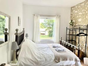 Un dormitorio blanco con una cama grande y una ventana. en Walnut Gite Sleeps 2 with Terrace, en Eymet