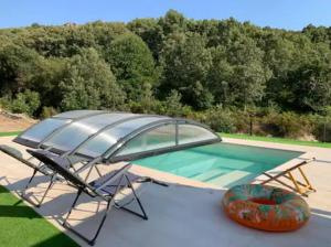 a swimming pool with a table and an umbrella at Quinta do Borges in Guarda
