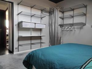 a bedroom with black shelves and a bed at Appartement cosy centre-ville wifi parking in Charleville-Mézières