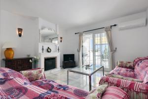 sala de estar con 2 sofás y chimenea en Quaint 2 Bedroom Townhouse with Pool close to Sea!, en Benalmádena