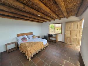 a bedroom with a bed and a wooden ceiling at Hotel Cariguá in Barichara