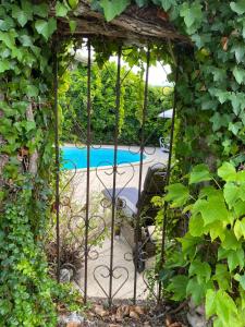 a garden gate with a pool in the background at Golden Fig Sleeps 6 with Pool in Eymet