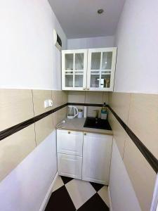 a small kitchen with white cabinets and a sink at Strumykowa 19 - Old Town in Toruń