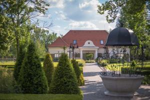 a large house with a garden with a fountain at Hercegasszony Birtok in Mezőtúr