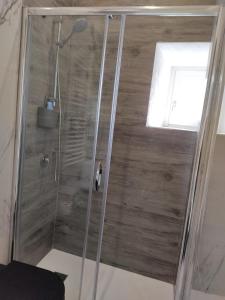 y baño con ducha y puerta de cristal. en Black & White, en Pietra Montecorvino