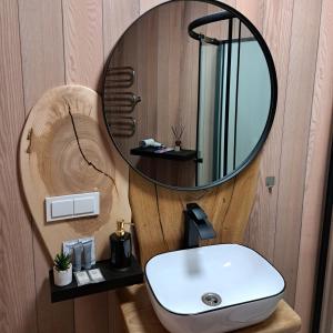a bathroom with a round mirror and a sink at Šventosios Slėnis 