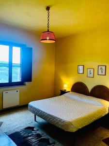 ein Schlafzimmer mit einem Bett und einem großen Fenster in der Unterkunft Azienda Agricola Colle Paradiso in Mompeo