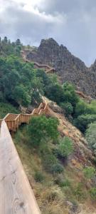 un pont en bois sur une colline avec une montagne dans l'établissement Quinta do Borges, à Guarda