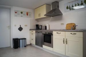 a kitchen with white cabinets and a stove top oven at Wohlfühlen am Großen Goitzschesee inkl. Netflix in Holzweißig