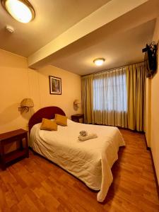 1 dormitorio con 1 cama blanca grande en una habitación en Hotel Vilandre, en Cusco