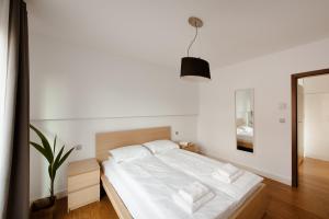 una camera da letto con un letto con lenzuola bianche e uno specchio di Spacious apartment close to Main Station / Galeria Krakowska a Cracovia