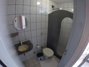 a small bathroom with a toilet and a mirror at POUSADA POLONINI - Localização ótima in Piúma