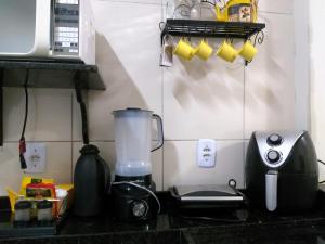 encimera de cocina con licuadora y tostadora en Flor de Peroba Flats #1 Amarelo - Maragogi - AL, en Maragogi