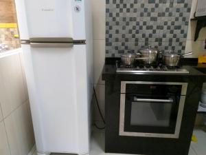 a refrigerator and a stove in a kitchen at Flor de Peroba Flats #1 Amarelo - Maragogi - AL in Maragogi