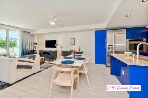 Una cocina y sala de estar con gabinetes azules y una mesa. en Stylish 1 BR at Fort Lauderdale, en Fort Lauderdale