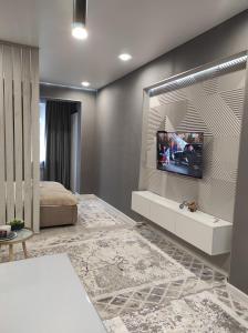 1 dormitorio con TV en la pared en Апартаменты ЖК Lotus Terrace en Almaty