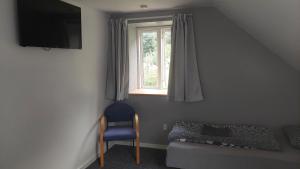 een kamer met een stoel, een raam en een bed bij Ringslund B&B in Galten