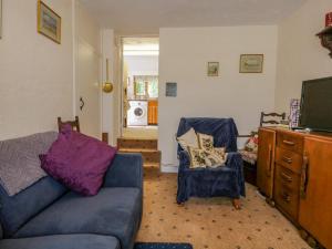 a living room with a couch and a tv at 2 Gateside Cottages in Coniston