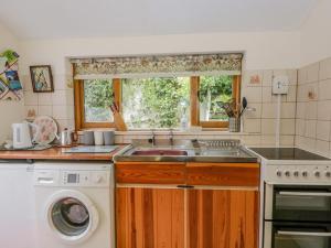 a kitchen with a sink and a washing machine at 2 Gateside Cottages in Coniston