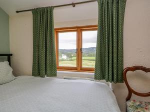 a bedroom with a bed and a window at 2 Gateside Cottages in Coniston