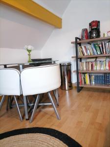 ein Zimmer mit einem Tisch, 2 Stühlen und einem Bücherregal in der Unterkunft Chez Sophie et Thibault in Sceaux-du-Gâtinais + 5 Fotos