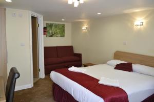 une chambre d'hôtel avec un lit et un canapé dans l'établissement Cranbrook Hotel, à Ilford