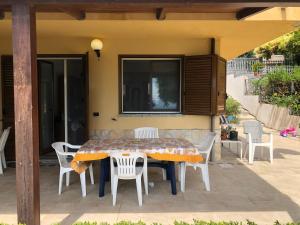 einen Tisch und Stühle auf einer Terrasse in der Unterkunft Appartamento fronte mare in Brancaleone Marina