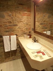 a bathroom with a sink and a mirror and towels at Hostal Virgen de la Encina in Ponferrada