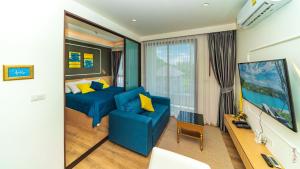a living room with a blue couch and yellow pillows at The Aristo-2-903 in Ban Lum Fuang