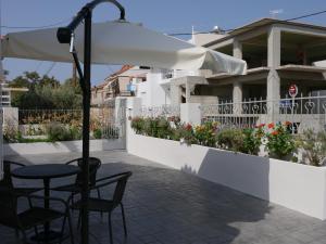 a patio with a table and chairs and an umbrella at TH Studio in Myrina