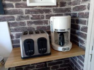 una macchinetta del caffè e una macchinetta del caffè su uno scaffale di Le gîte de la salicorne a Marck