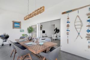 a dining room with a wooden table and chairs at Belnem Breeze Kas Gosa in Kralendijk