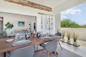 a dining room with a wooden table and chairs at Belnem Breeze Kas Gosa in Kralendijk