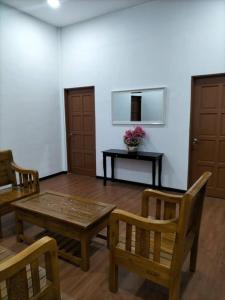 加央的住宿－Kangar Jaya Lodging，客厅配有桌子、两把椅子和一张桌子