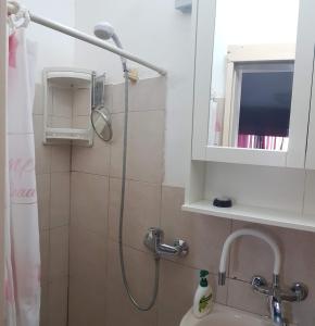 y baño con ducha y lavamanos. en Cozy Flat with Parking well-placed near TLV Airport, en Lod