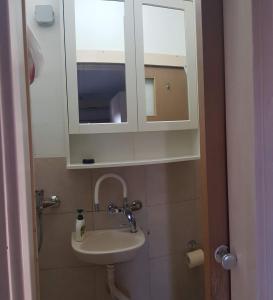 ein Badezimmer mit einem Waschbecken und einem Medizinschrank in der Unterkunft Cozy Flat with Parking well-placed near TLV Airport in Lod