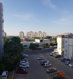 a parking lot with parked cars in a city at Cozy Flat with Parking well-placed near TLV Airport in Lod