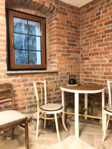 a room with two tables and chairs and a brick wall at Dolina Zdrowia u Skrzypków in Wleń