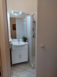 a bathroom with a sink and a shower and a mirror at La Finestra sui Faraglioni in Capri