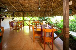 ein Esszimmer mit Tischen und Stühlen in einem Restaurant in der Unterkunft Hotel La Aldea del Halach Huinic in Palenque