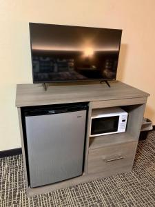 a entertainment center with a tv and a microwave at Riverchase Lodge in Pigeon Forge