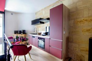 une cuisine avec un réfrigérateur rose et une table dans l'établissement Mieuxqualhotel jacuzzi privatif Love room, à Bordeaux