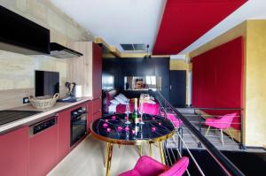 a kitchen with pink chairs and a table in a room at Mieuxqualhotel jacuzzi privatif Love room in Bordeaux +6 photos