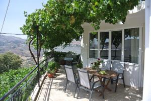 a table and chairs on the balcony of a house at House Aggeliki Private Hot Tub in Kissós