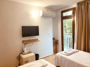 a hotel room with two beds and a flat screen tv at Casa Beach in Ravda