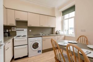 a kitchen with a table and a stove and a dishwasher at Pipelands Road in St. Andrews