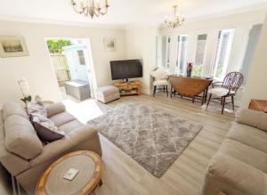 a living room with a couch and a television at Pears Grove - Southbourne in Emsworth